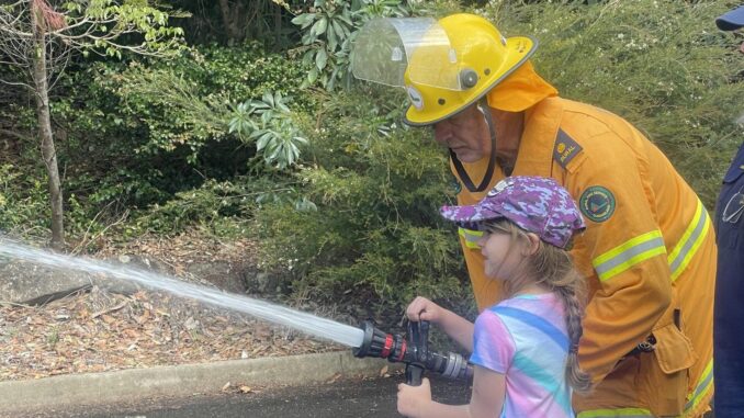 Phil Rankin, Beechmont RFS Third Officer shows Mahina Folwer how to use the fire hose